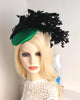 Elegant emerald green hat with cascading black feathers